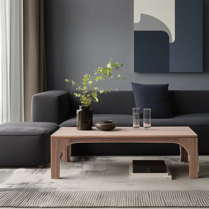 Arched leg coffee table styled in soft living room setting with sculptural presence and clean layout