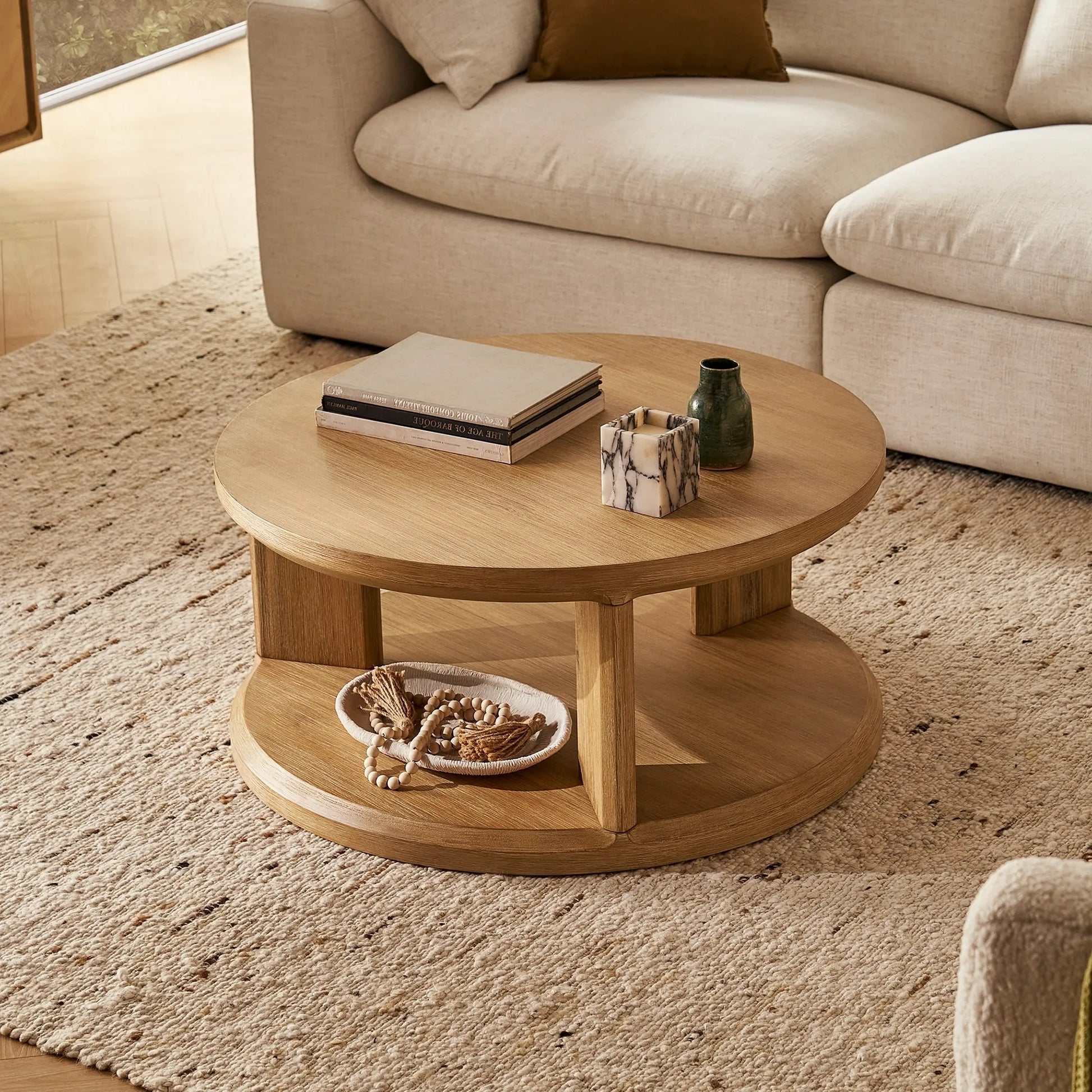 Elegant round coffee table with a spacious surface and open storage shelf