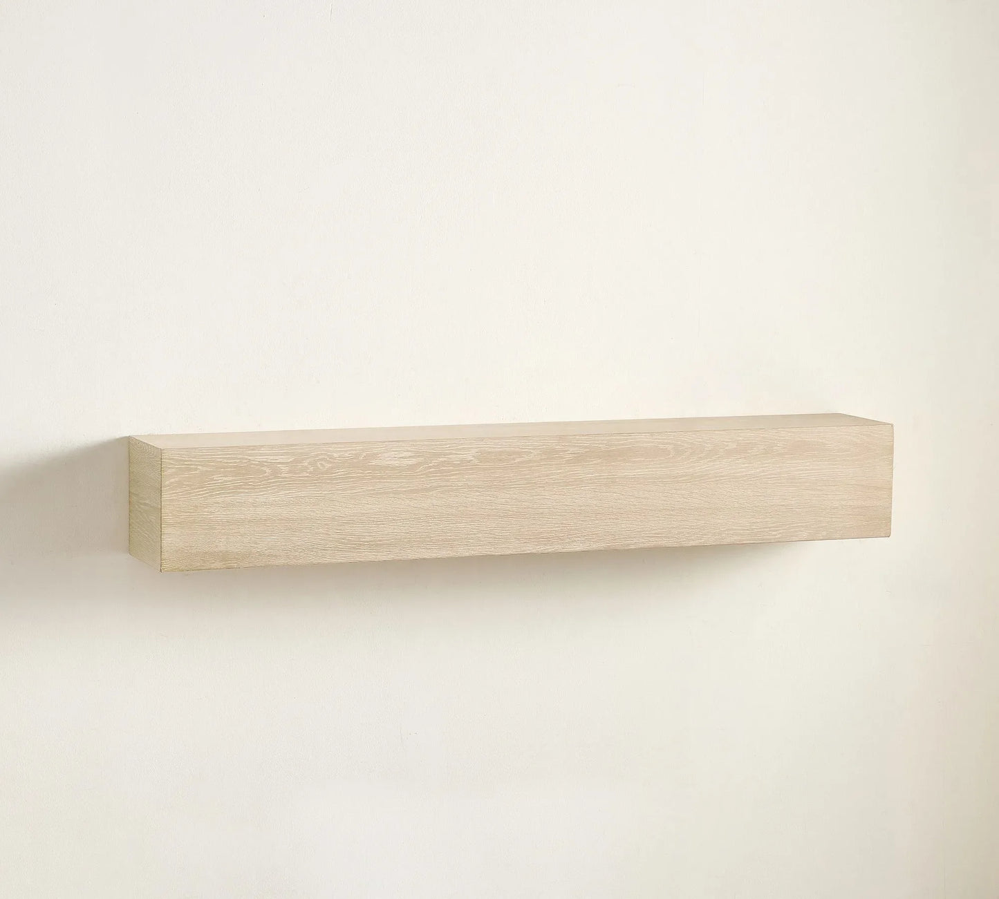 Elegant wall shelf decorated with framed art, candles, and sculptures