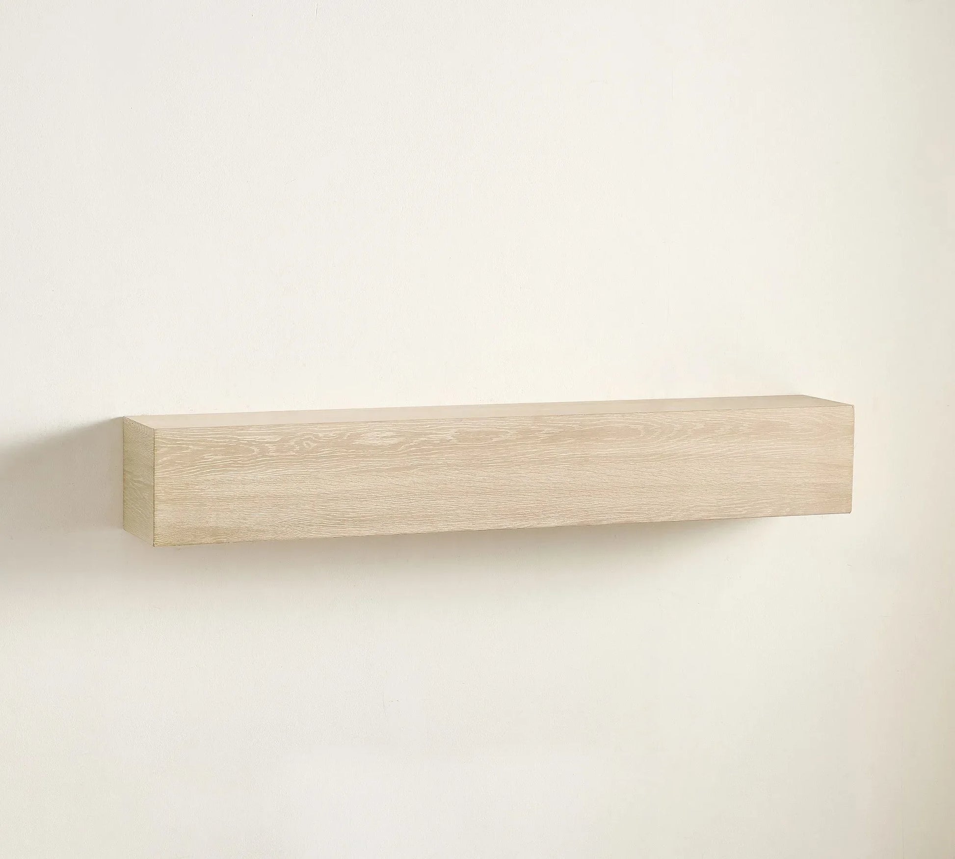 Elegant wall shelf decorated with framed art, candles, and sculptures