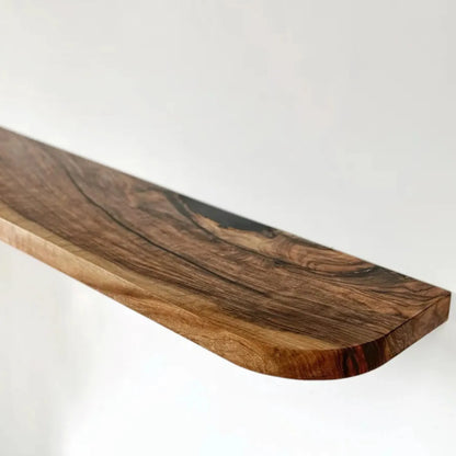 Floating storage shelf mounted on a white wall displaying decorative items and books