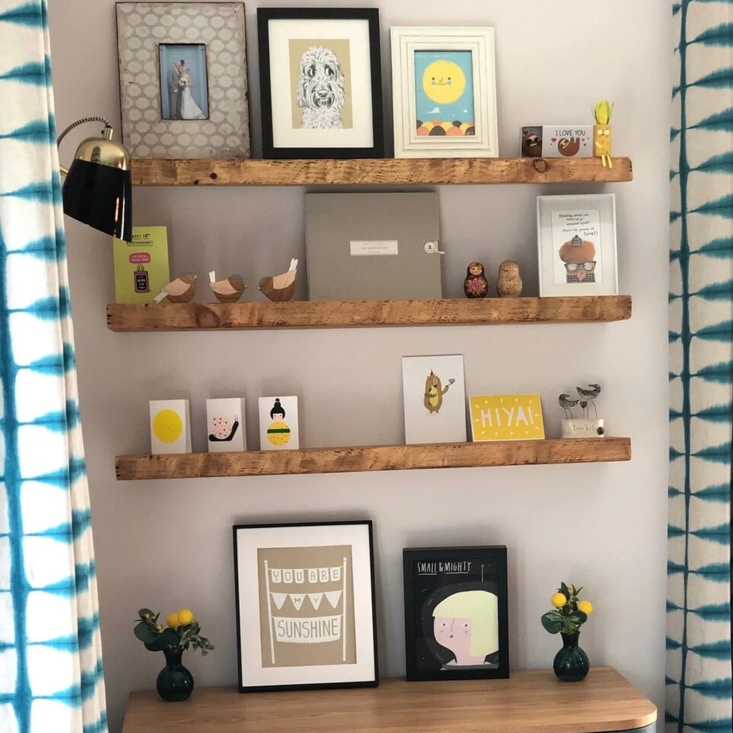 Live edge wall shelf mounted on a white tiled wall displaying decorative items and books