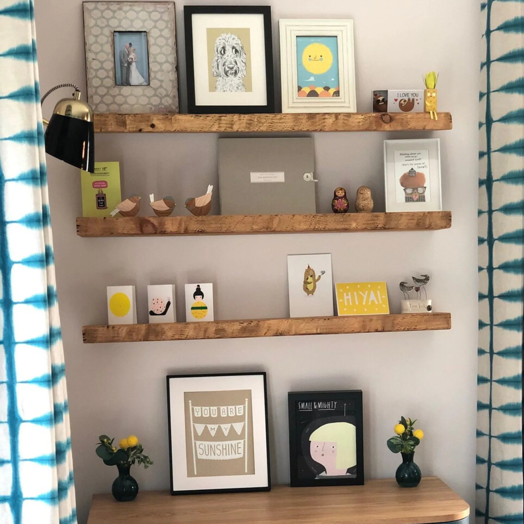 Live edge wall shelf mounted on a white tiled wall displaying decorative items and books