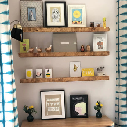 Live edge wall shelf mounted on a white tiled wall displaying decorative items and books