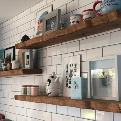Live edge wall shelf mounted on a white tiled wall displaying decorative items and books
