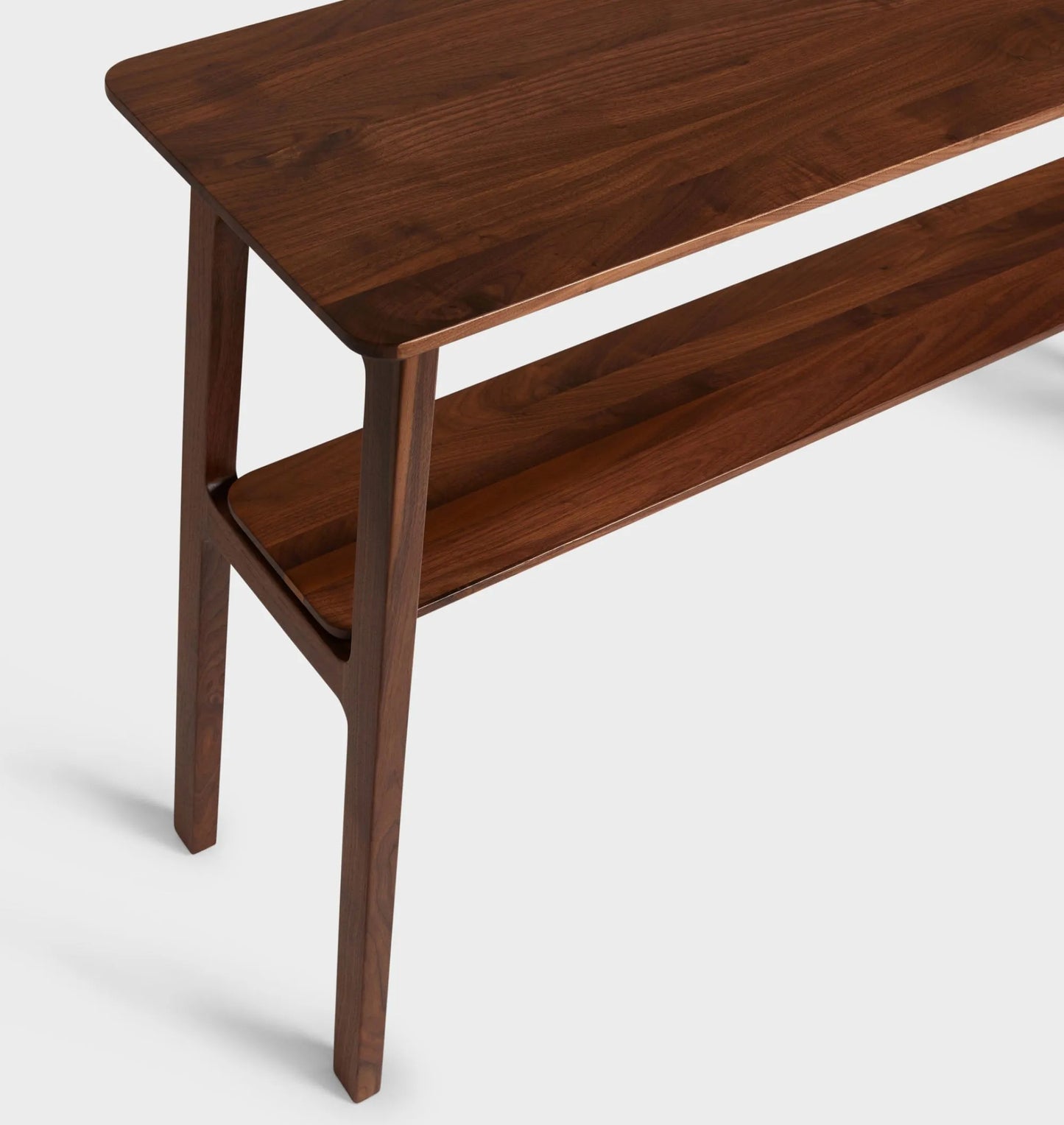 Mid century console table featuring open design, tapered legs, and dual shelves for storage.