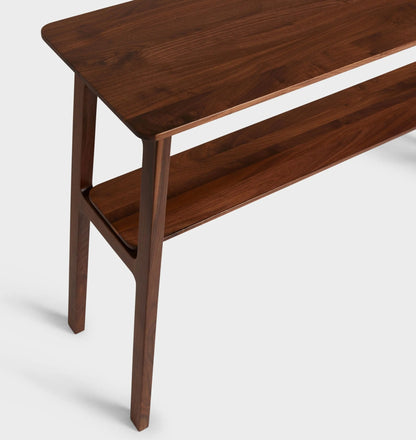Mid century console table featuring open design, tapered legs, and dual shelves for storage.