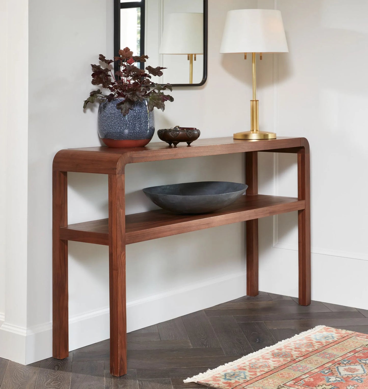 Mid century console table with rounded edges and two-tier shelves for decor and storage.