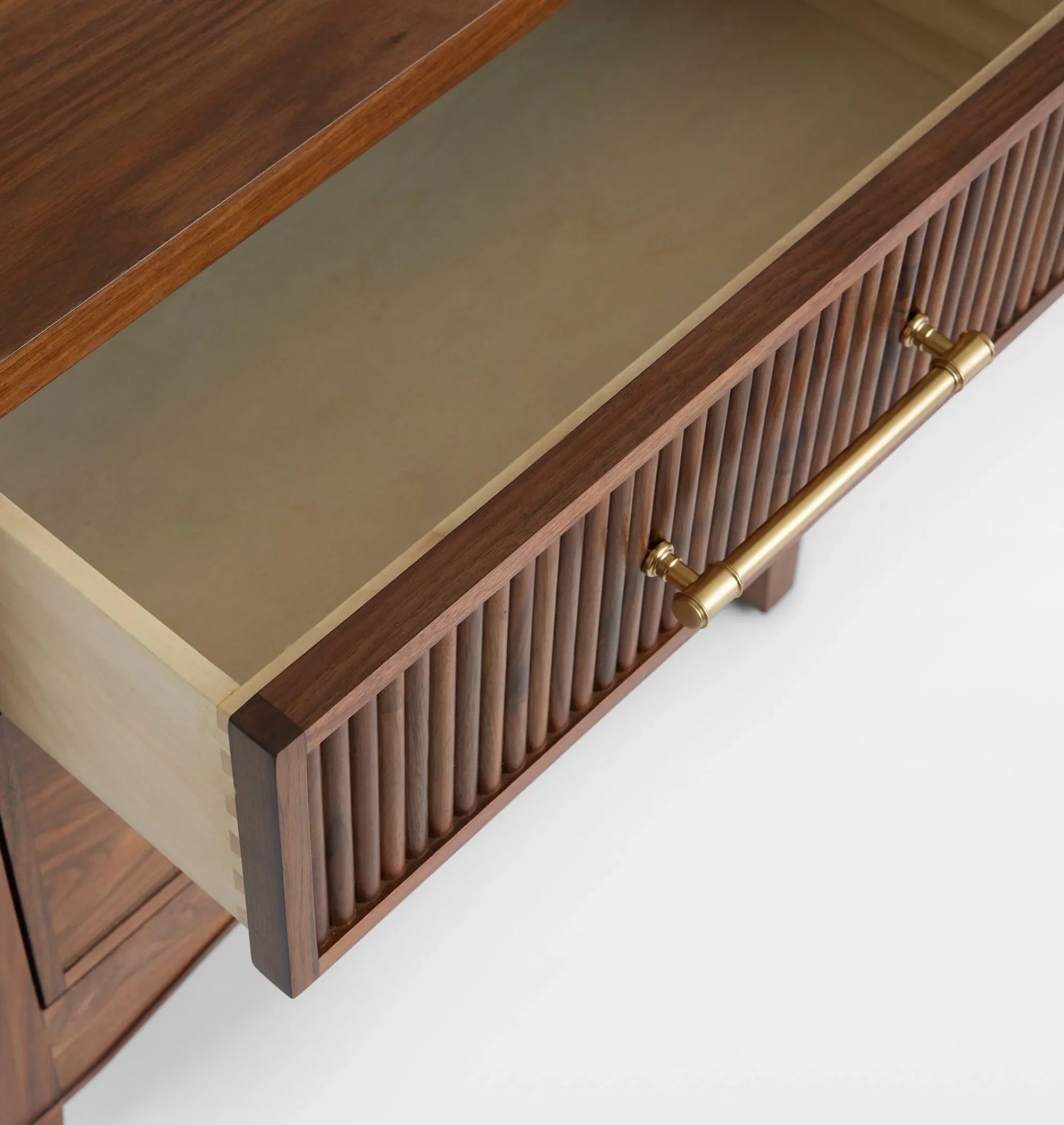 Mid century nightstand with ribbed drawer design, golden handles, and arched base.