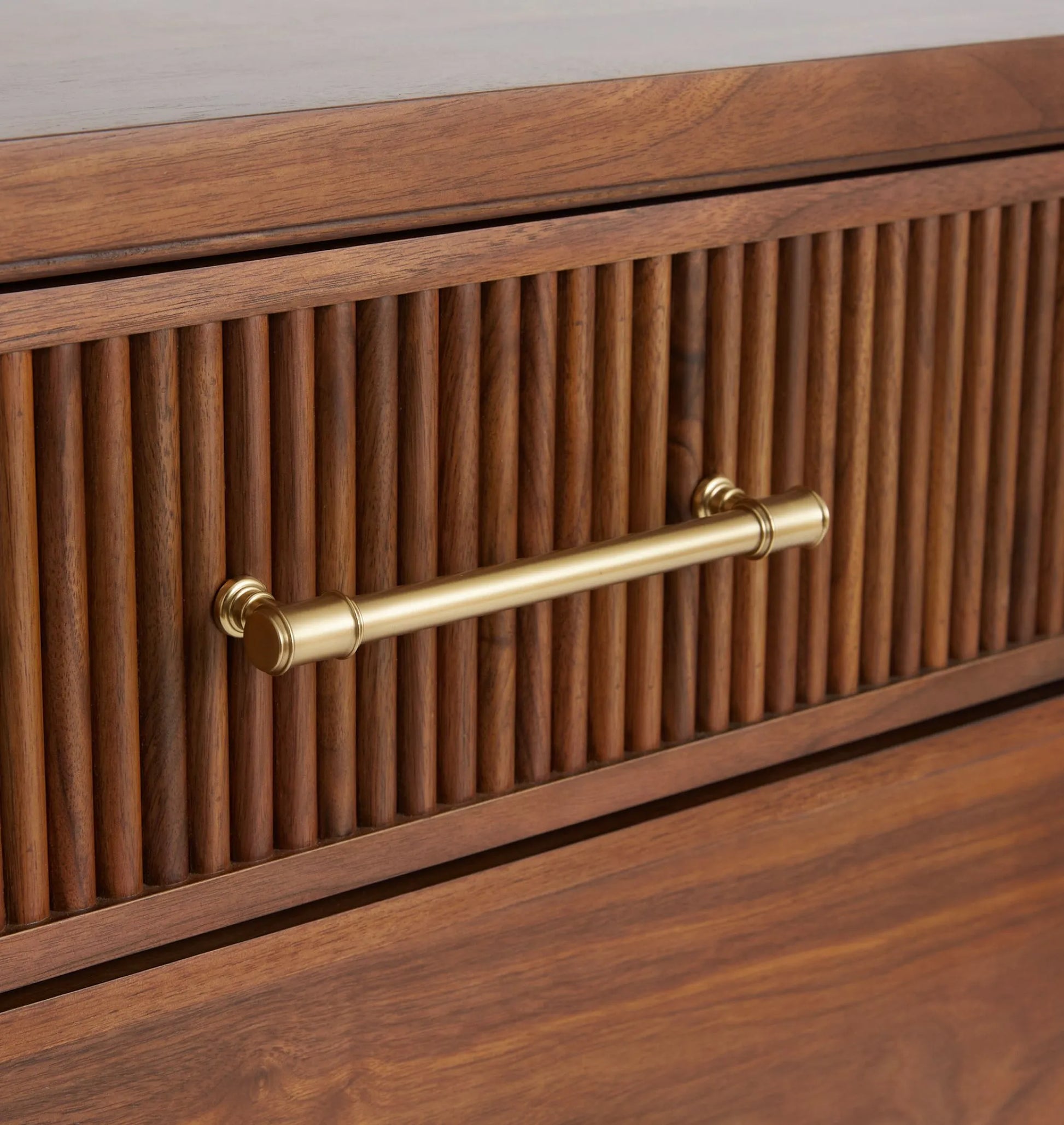 Mid century nightstand with ribbed drawer design, golden handles, and arched base.