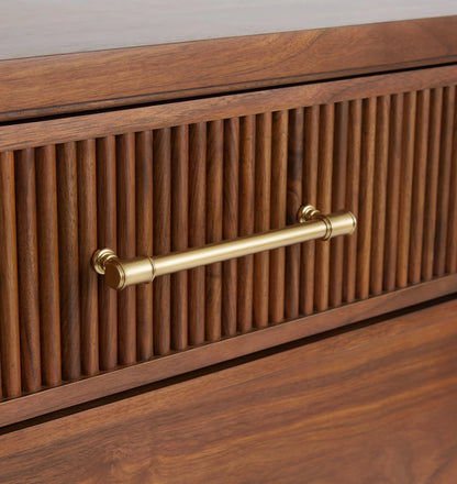 Mid century nightstand with ribbed drawer design, golden handles, and arched base.